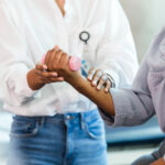 Woman exercising with hand weight is guided by occupational therapist