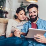 Couple using an iPad while holding a credit card