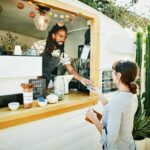 Small business owner hands card back to customer.