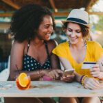 Two women planning a trip over drinks