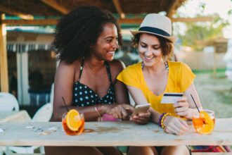 Two women planning a trip over drinks