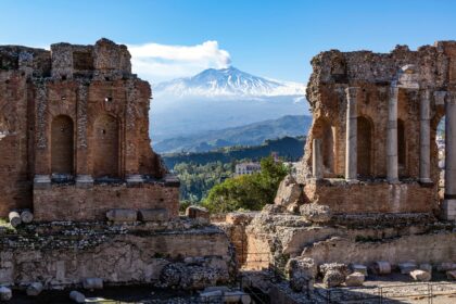 Volcano Etna in Sicily seen through ruins of ancient amphitheater in Taormina
