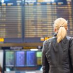 Female traveller checking flight departures board.