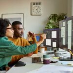 Multiracial colleagues discussing over computer