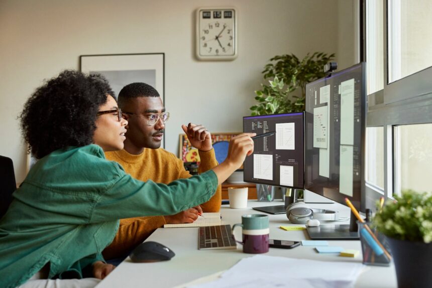 Multiracial colleagues discussing over computer