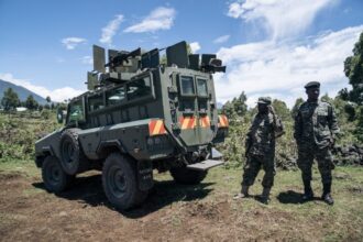 Ugandan soldiers from the East African Community Regional Force (EACRF) stand guard near one of their bases in Bunagana, on 19 April 2023.