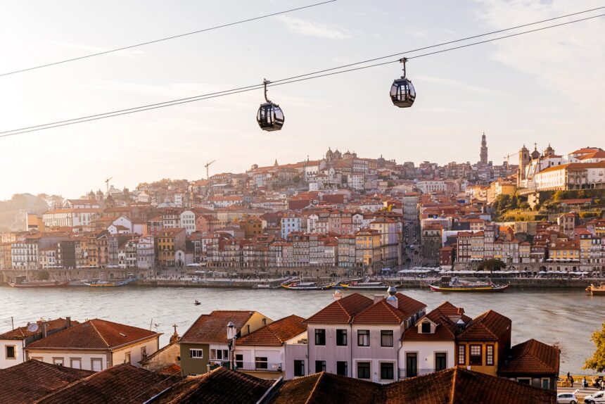 Cable car cabins moving above Porto city and Douro river at sunset, Portugal