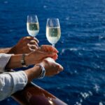 Hands holding champagne glass on cruise ship