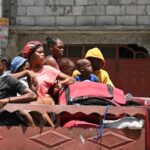 Locals evacuate the Carrefour Feuilles commune in Port-au-Prince, Haiti, as gang violence continues, 15 August 2023.