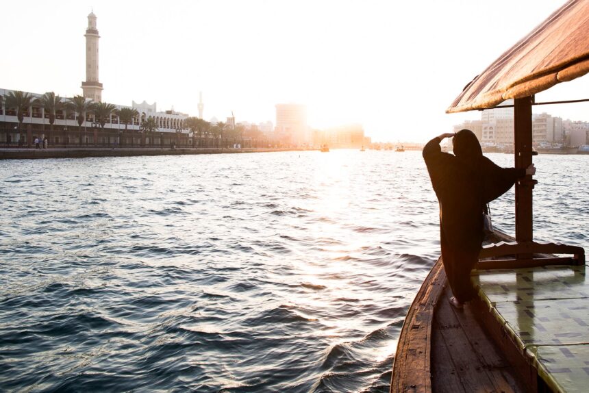 arab woman crossing Dubai Creek on a boat