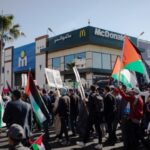 A demonstration of support for Palestine passes in front of McDonald