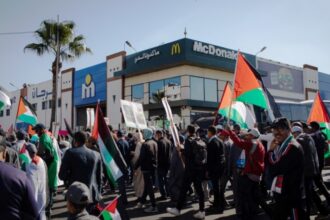 A demonstration of support for Palestine passes in front of McDonald