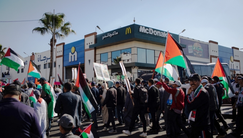 A demonstration of support for Palestine passes in front of McDonald