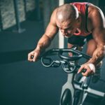 Man on stationary bicycle working hard.