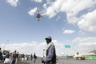 A helicopter flies over a crowd.